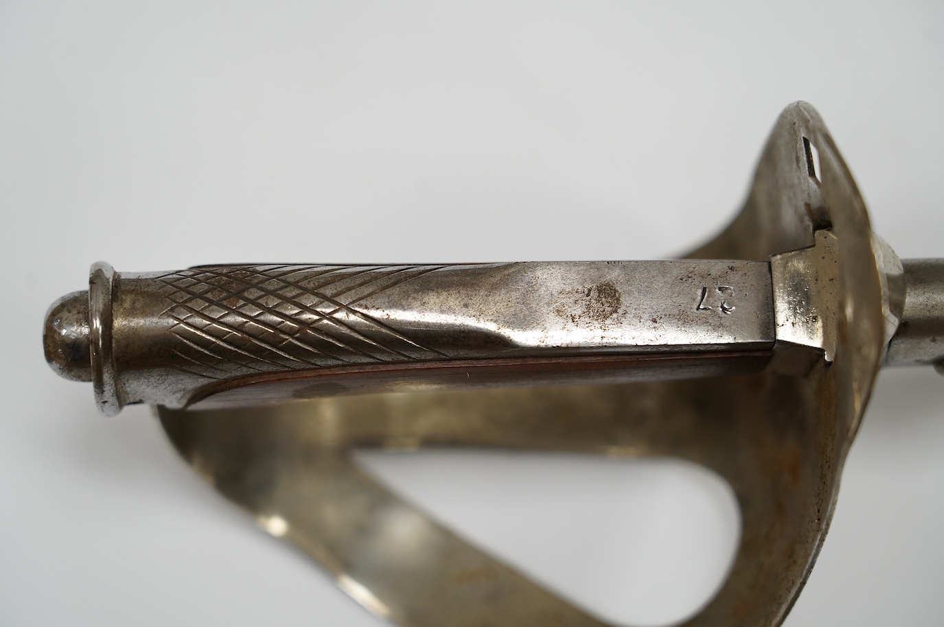 An Italian WWI cavalry trooper’s sword, pipe back blade, pierced guard, wooden grip, in its steel scabbard, blade 91cm. Condition - fair